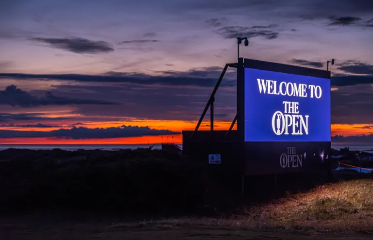 Welcome to The Open LED screen at dusk, with a CCTV camera on the tower